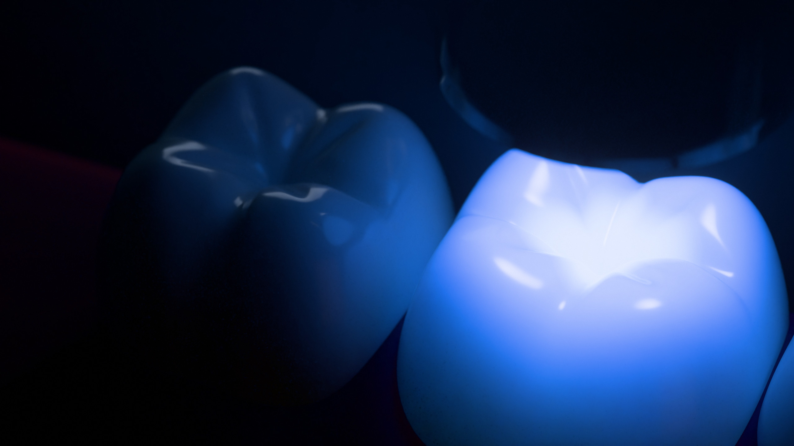 A filling in a back tooth glowing under the curing light.